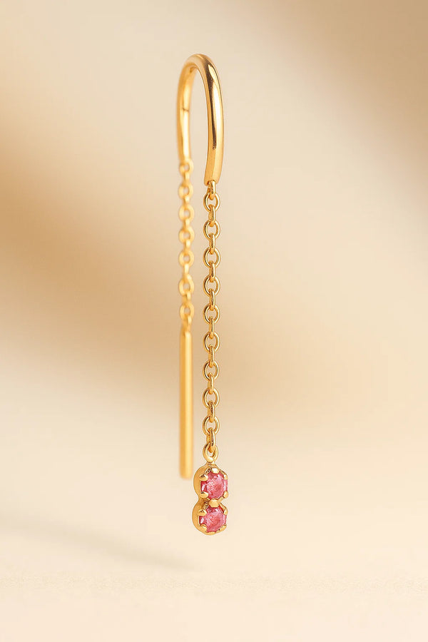 Arete individual con zafiro rosa colgando de una cadena fina de oro 18k