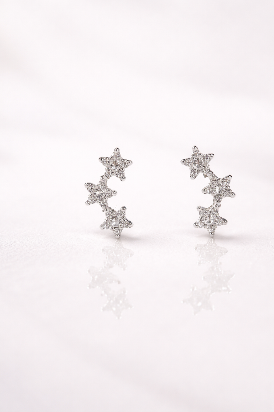 Arete individual de tres estrellas con diamante en oro